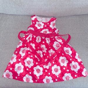 Pink Dress with white flowers, along with a Zipper & straps to tie in the back.